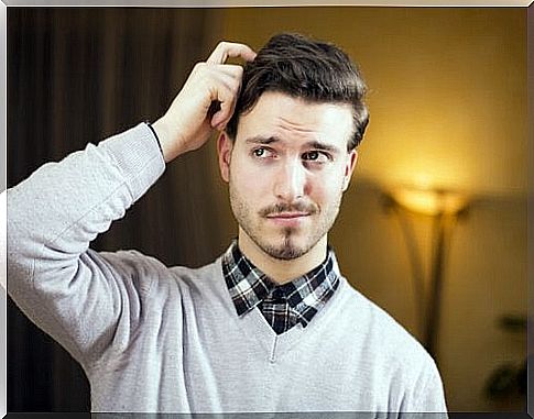 Man scratching his head while thinking a lie