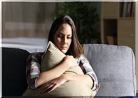 Woman hugging a cushion eating her head