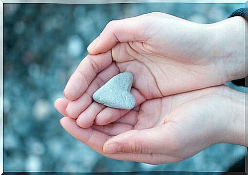 Hands with a stone heart symbolizing the phrases of the Tao