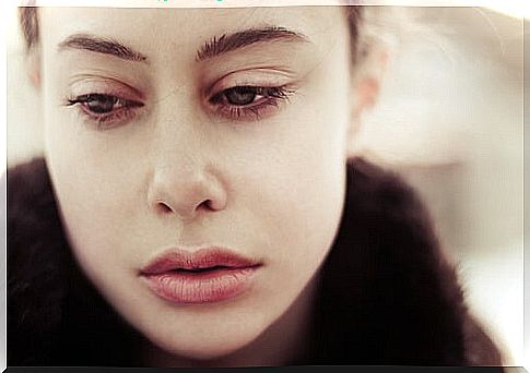 Woman looking down with sadness suffering a lack of affection