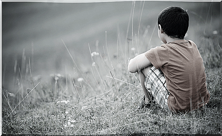 child sitting on his back thinking about being happy after having lived through a traumatic childhood