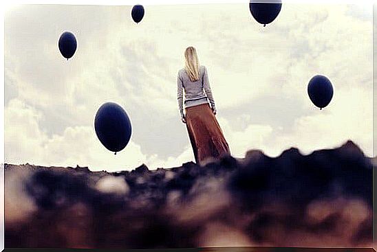 girl wrapped in dark balloons depicting creative hopelessness