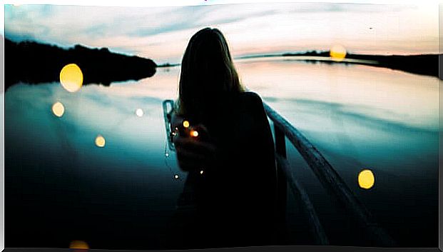 Woman from behind looking at a river thinking about the magic of connection