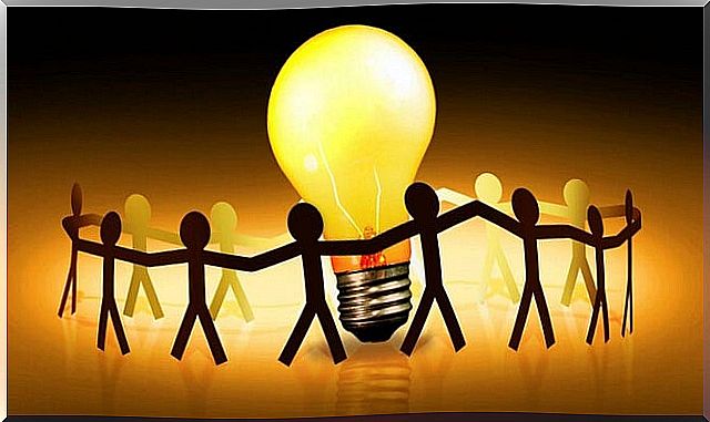 Figures surrounding light bulb fostering positive attitude