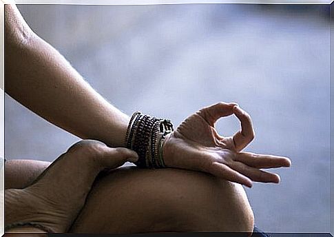 Arm over leg of a woman meditating