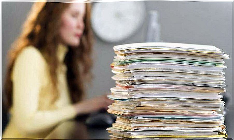 girl with accumulated papers thinking of leaving everything for the last moment