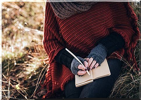 Woman writing with pen in a notebook