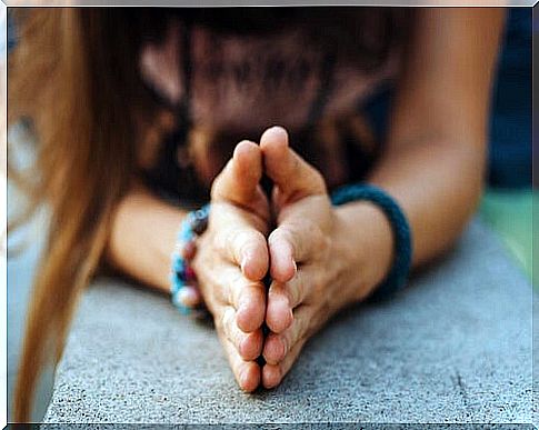 Woman putting her hands together on a stone