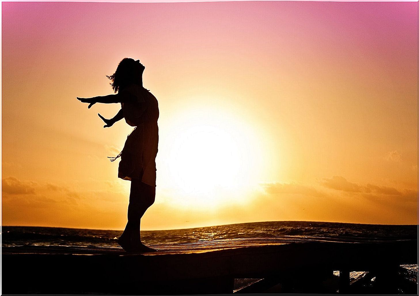 woman at sunrise symbolizing how to be happier after middle age