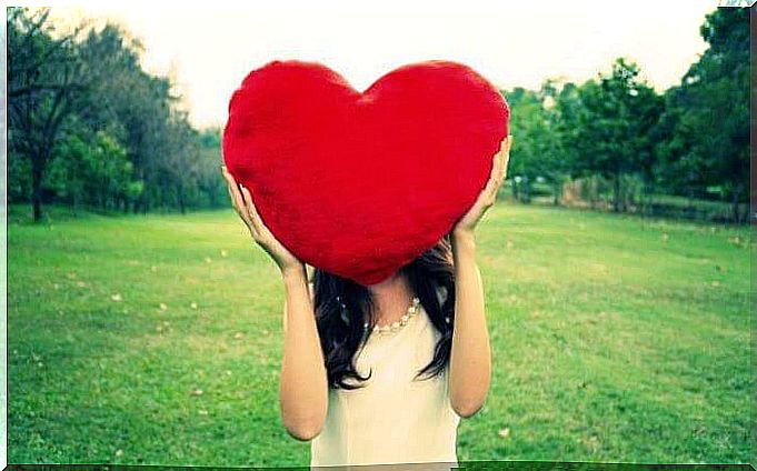 Woman with high self esteem holding a huge heart