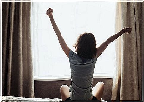 Woman with open arms when waking up