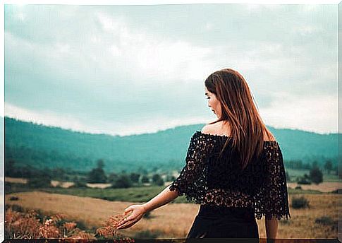 Woman walking through the field in autumn