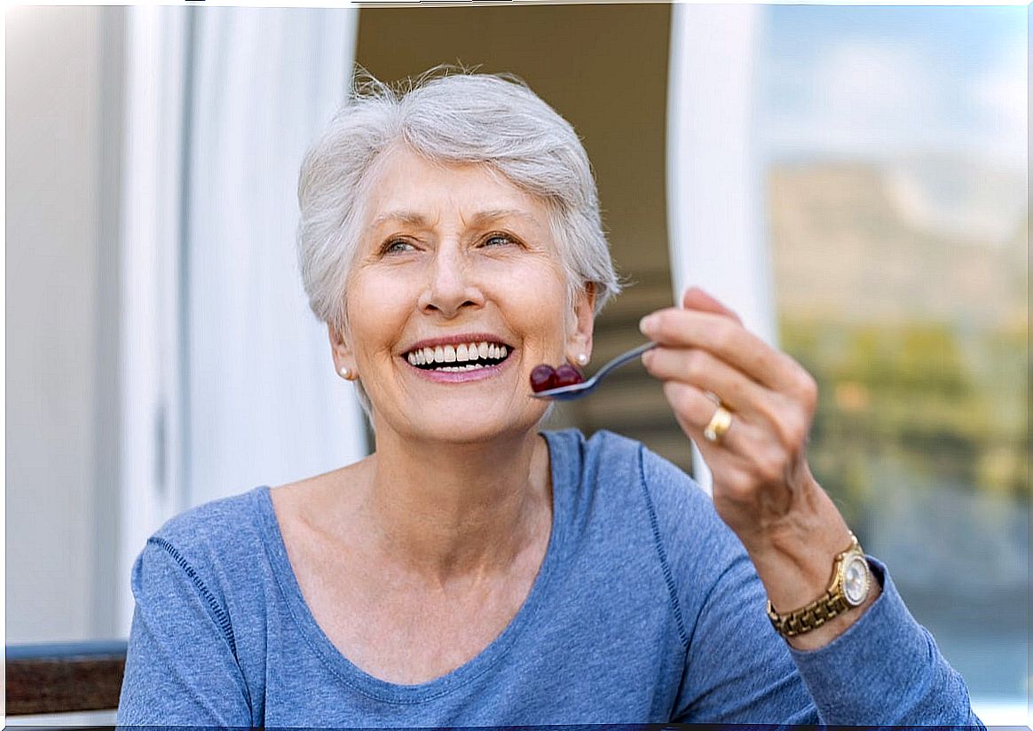 Senior woman eating red grapes