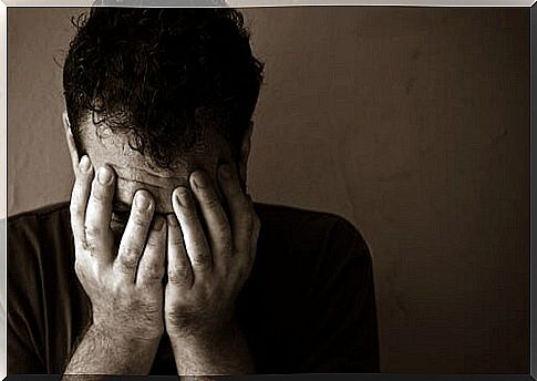 Depressed man with hands on his face