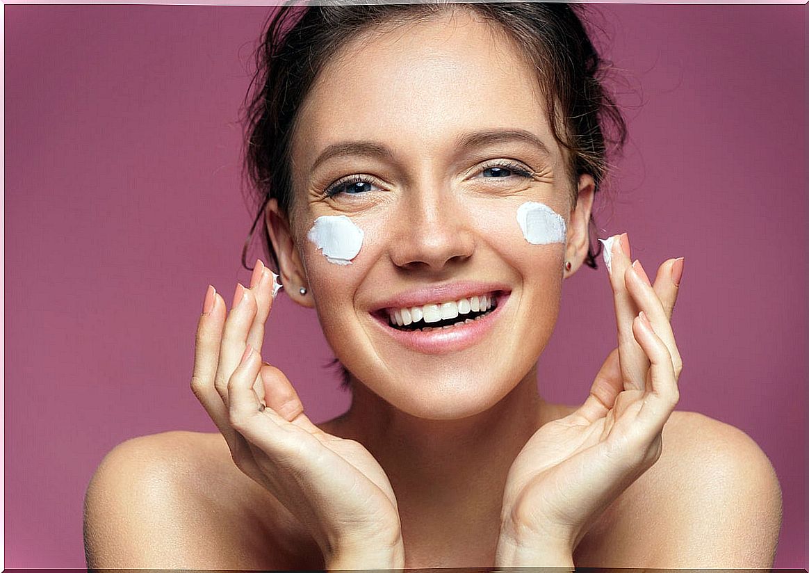 Woman putting cream on her face