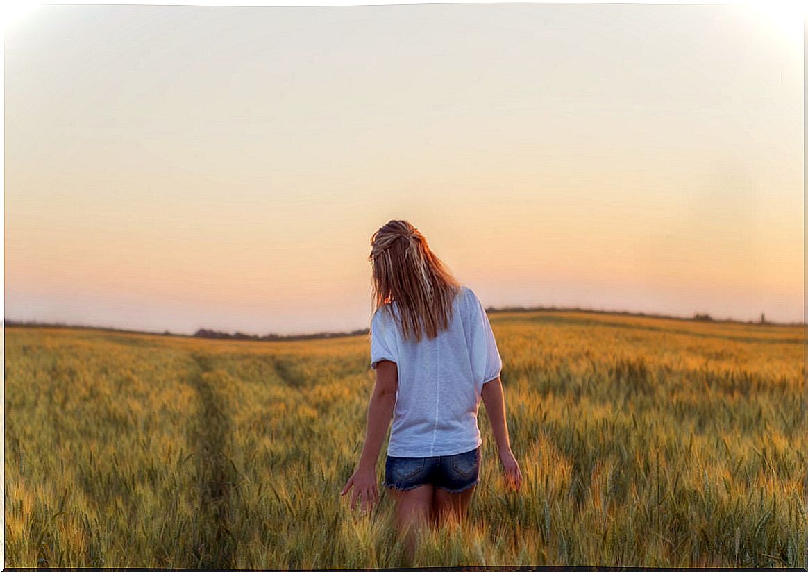 Woman in a wheat field thinking that wanting is not power